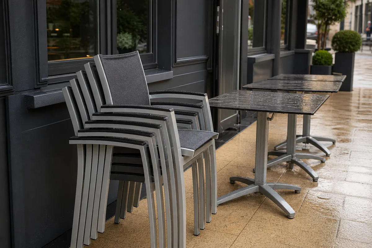 Chaises et tables en aluminium empilables sur une terrasse de restaurant prête pour le service
