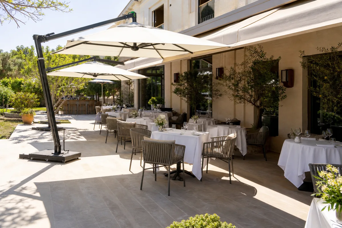 Terrasse de restaurant ombragée par des parasols déportés au-dessus de tables dressées