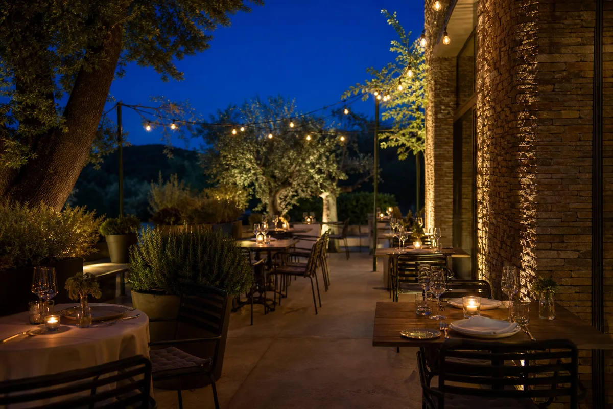 Terrasse de restaurant en soirée, tables dressées et éclairage chaleureux à la tombée du jour