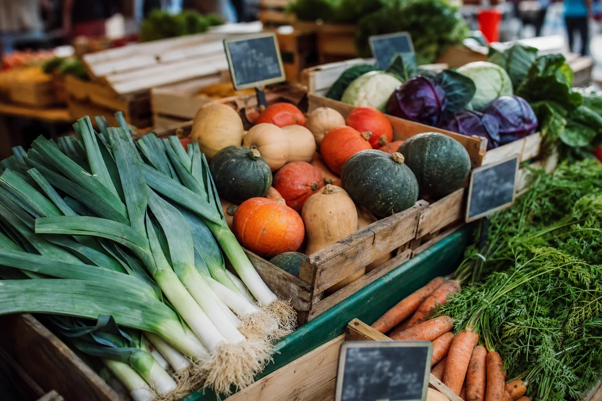 Étal de marché avec légumes bio de saison en cagettes de bois